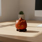 Quirky wooden campfire ornament with yellow eyes on a modern office desk, FantasyCraft Shop
